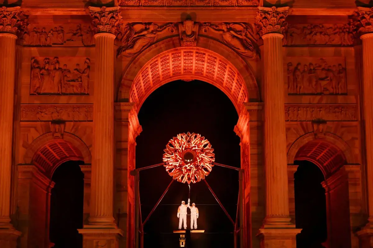 أسطورتا التزلج الإيطاليان تومبا وكومبانيوني يوقدان المرجل الأولمبي في ميلان